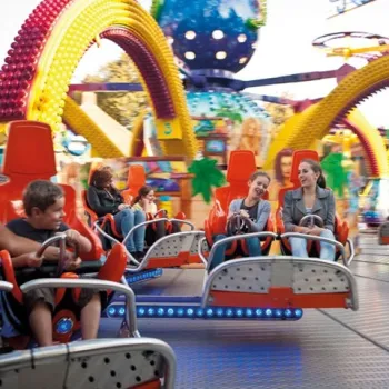 Kinderen en volwassenen in een attractie tijdens een kermis in Weert, een populair uitje voor het hele gezin.